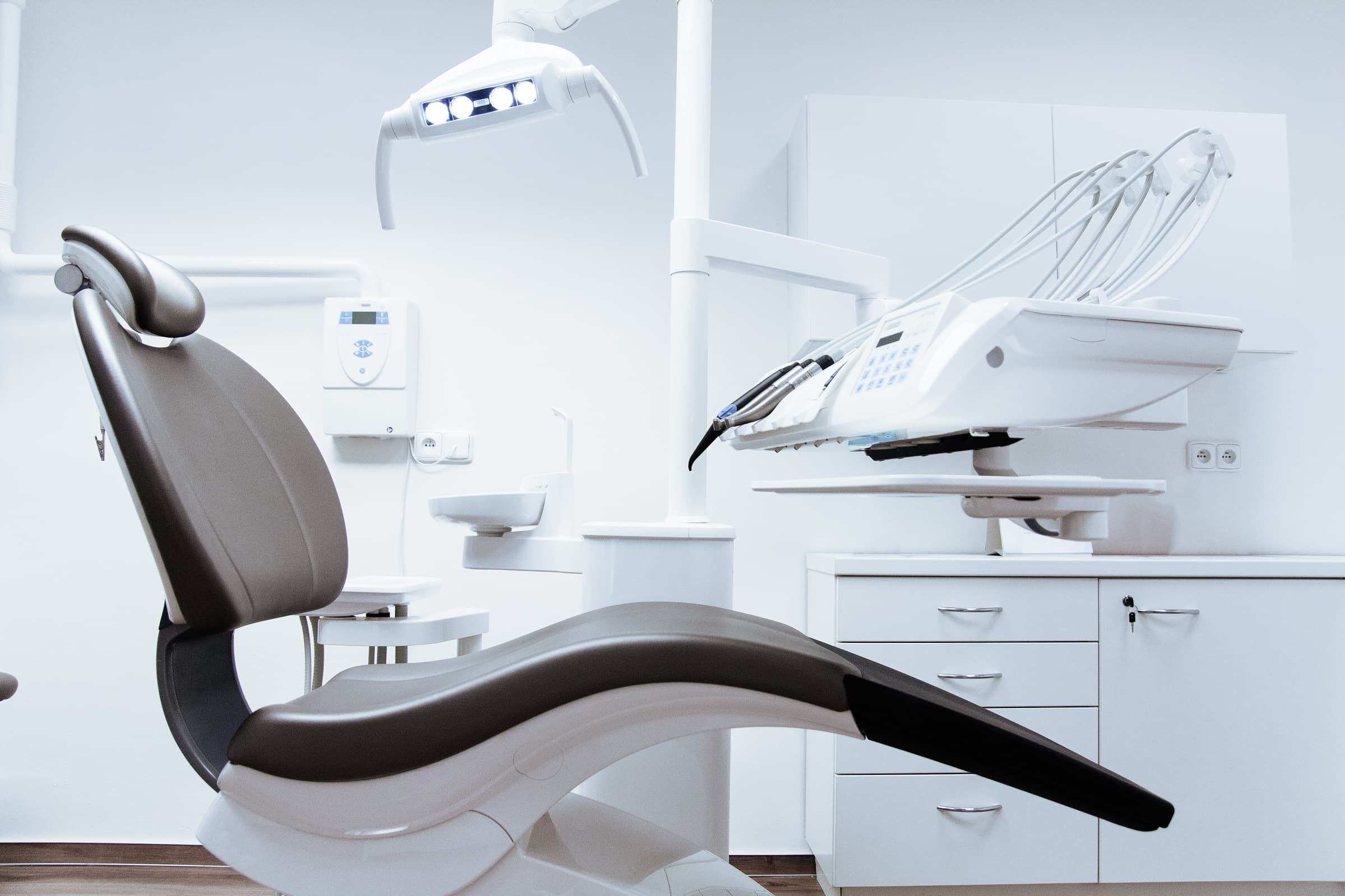 A bright treatment room with a dental chair by the window