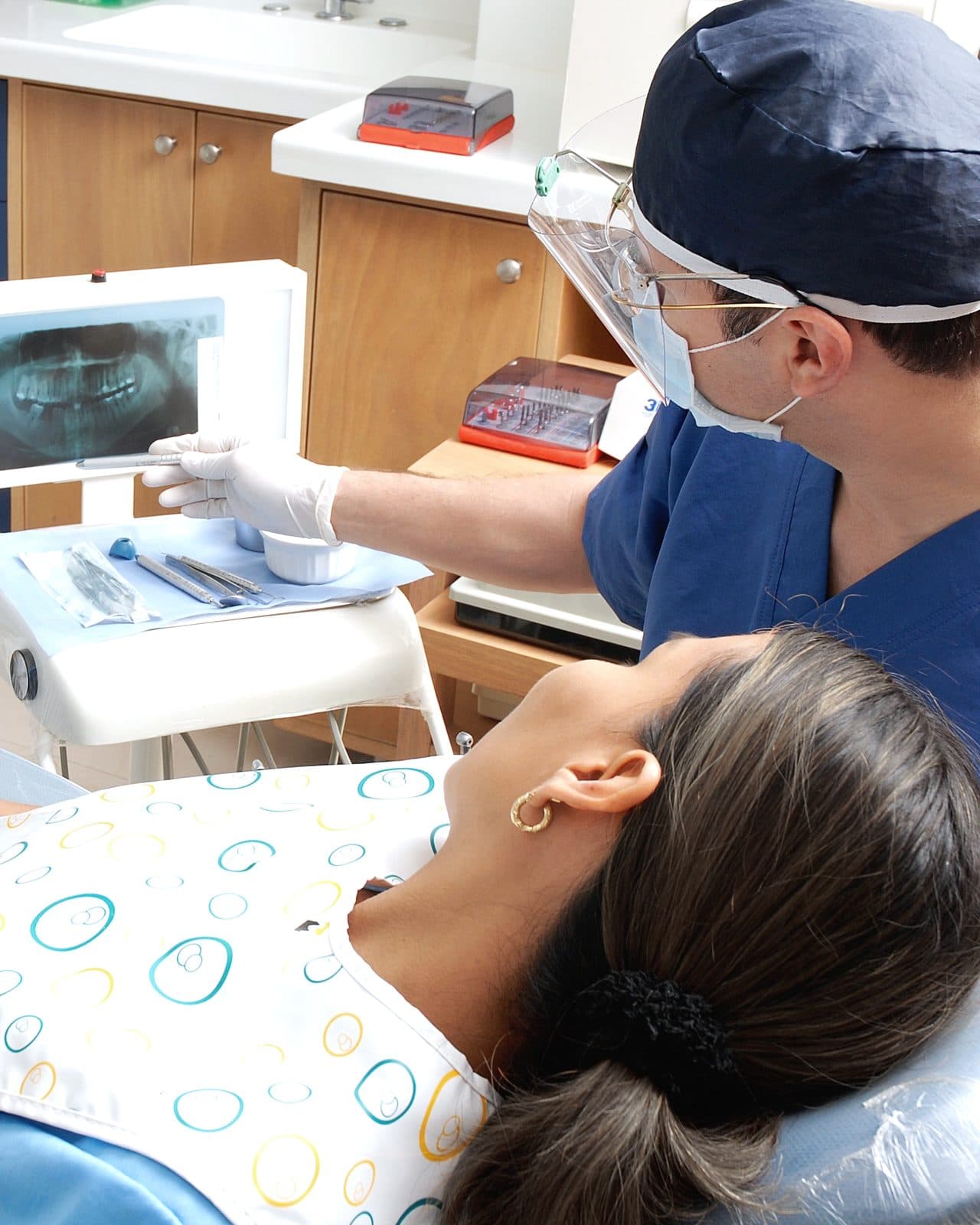 A dentist at work beside the treatment chair