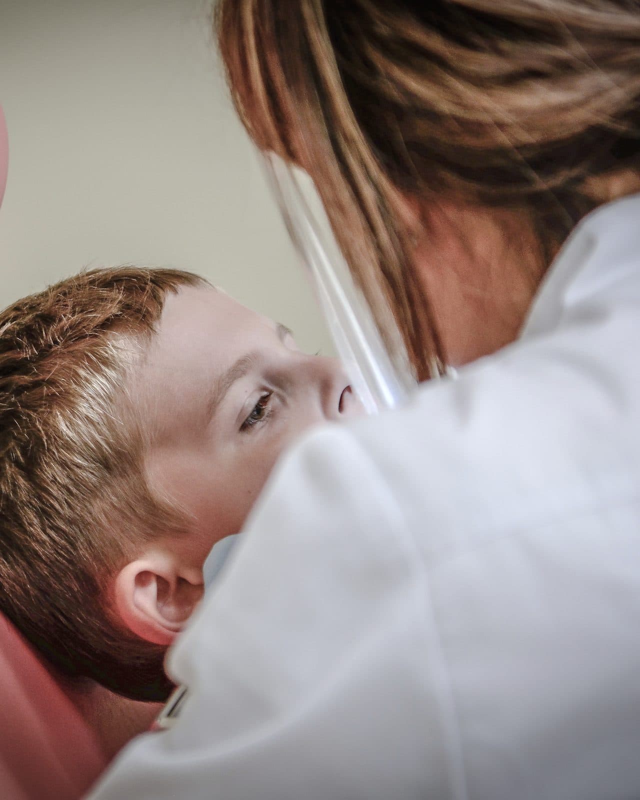 A dentist treating a young patient in the chair